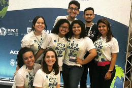 Imagem: Os oito integrantes da equipe, sendo seis em pé e dois agachados, durante participação na etapa local do hackathon (Foto: Divulgação)