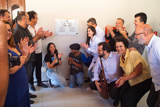 Imagem: Em semicírculo, autoridades acadêmicas, políticas e estudantes descerram juntos a placa de inauguração no espaço que abrigará o Restaurante Universitário do Campus de Itapajé. (Foto: Viktor Braga/UFC Informa)