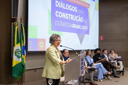 Imagem: Vice-reitora Diana Azevedo fala no púlpito ao público presente no auditório da FIEC