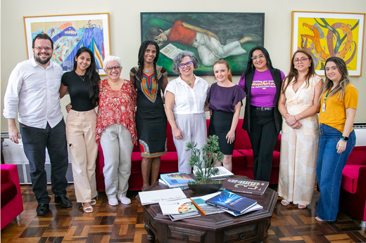 Imagem: De pé, no Gabinete da Reitoria, um homem e oito mulheres posam após reunião sobre acordo de cooperação entre UFC, Secretaria das Mulheres e Conselho Cearense dos Direitos da Mulher. (Foto: Álvaro Graça Jr./ UFC Informa)