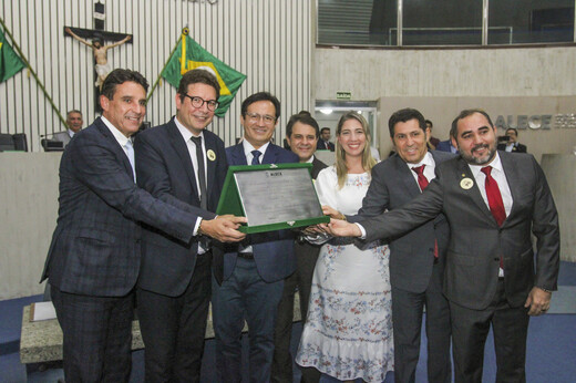 Imagem: O reitor Custódio Almeida (ao centro) segura com diversos deputados estaduais o título de Cidadão Cearense, recebido no plenário da Assembleia Legislativa.