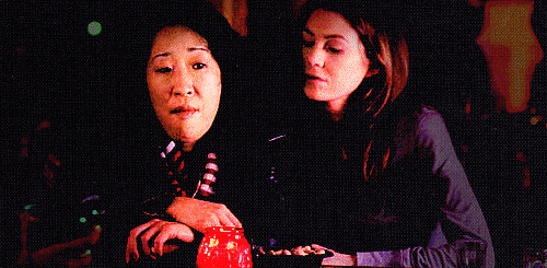 Personagens Meredith Grey, da série Grey's Anatomy, abraça a amiga Christina Yang e coloca a cabeça em seu ombro