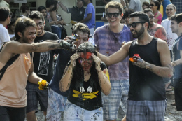 Imagem: Estudantes jogando tinta em aluna ingressante na Universidade 