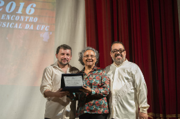 Imagem: Os professores Gerardo Júnior e Elvis Matos entregaram placa Izaíra Silvino (Foto: Jr. Panela / UFC) 