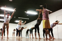 Imagem: Grupo de pessoas se alongando numa sala de dança 