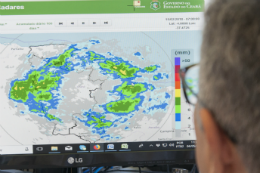 Imagem: Prof. Assis olhando para mapas na tela de computador