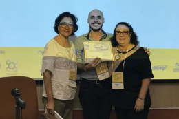 Imagem: Arquiteto Plínio Silveira com certificado na mãe, entre duas mulheres, no evento