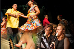 Imagem: foto com pessoas dançando e tocando instrumentos