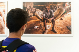 Imagem: Foto de rapaz de costas olhando foto exposta no Museu da UFC