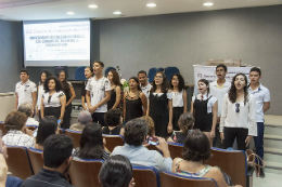 Imagem: Coral de estudantes de escolas públicas se apresentando frente às pessoas da plateia (Foto: Viktor Braga/UFC)