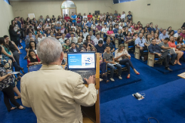 Foto do Reitor da UFC Henry Campos discursando no púlpito para um auditório lotado