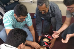 Imagem: foto de servidores manuseando manequim com capacete no curso anterior