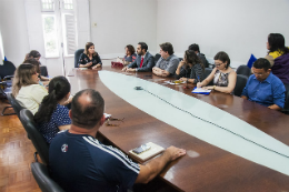 Imagem: foto de pessoas reunidas em uma mesa de reunião