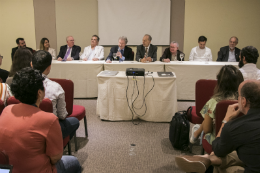 Foto da mesa e de participanets na plateia