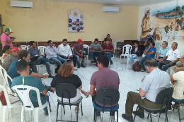 Imagem: Foto de várias pessoas - maioria homens - sentados em cadeiras em formato de círculo