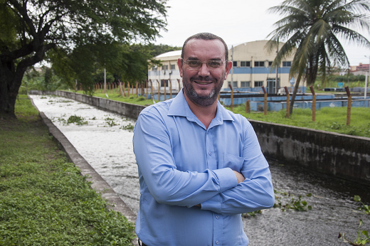 Imagem: O professor Daniel Albiero, em foto da cintura para cima, de braços cruzados, usando camisa azul, em uma área verde do Cento de Ciências Agrárias da UFC (Foto: Ribamar Neto/UFC)