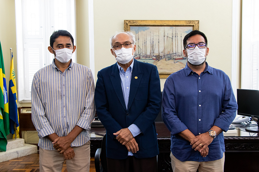 Imagem: três homens de roupas sociais posam para foto