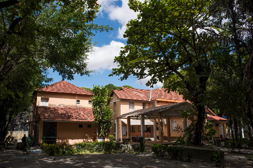 Imagem: Foto das Casas de Cultura Portuguesa e Hispânica da UFC emolduradas por árvores