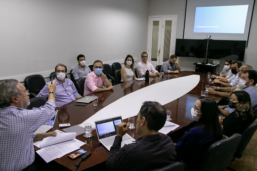 Várias pessoas sentadas ao redor de uma mesa, durante reunião do CATI (Foto: Viktor Braga/UFC)