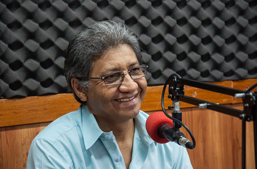 Imagem: Professor Nonato Lima no estúdio da rádio Universitária FM, sorrindo próximo a um microfone (Foto: Viktor Braga/UFC)