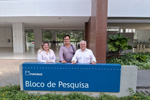 Imagem: Foto posada atrás da placa escrita "FIOCRUZ Bloco de Pesquisa" com a coordenadora Carla Celedônio, o reitor Custódio Almeida e o coordenador de Inovação Odorico Monteiro