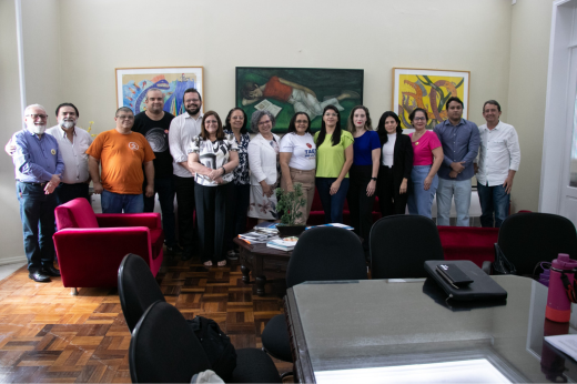 Imagem: De pé, no Gabinete da Reitoria, sete homens e oito mulheres posam; ao centro, está a vice-reitora Diana Azevedo. (Foto: Gladson Caldas/ UFC Informa) 