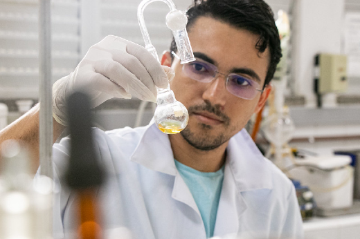 Imagem: Pesquisador em laboratório segurando frasco com substância 