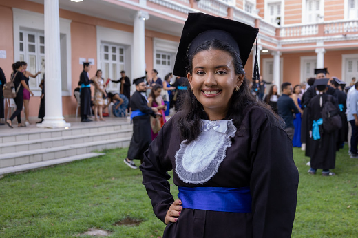 Imagem: Formanda posa para foto no jardim da Reitoria 