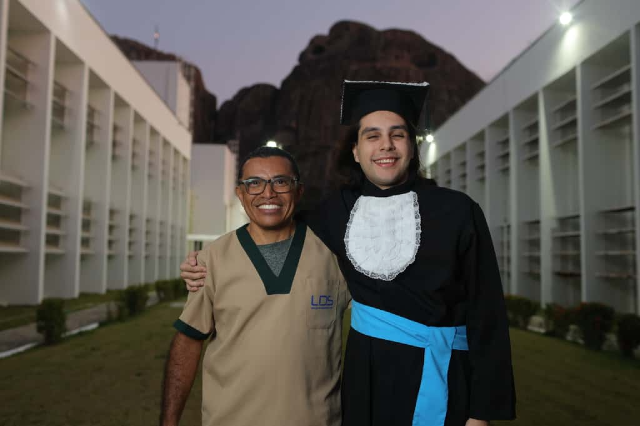 Imagem: Homem com uniforme e jovem de beca 