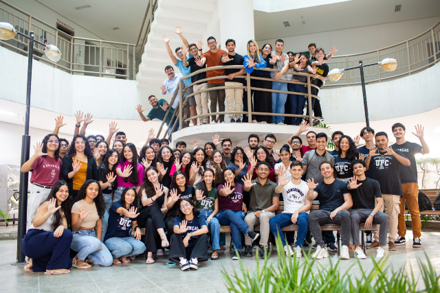 Imagem: vários jovens posam para foto fazendo um 5 com mão