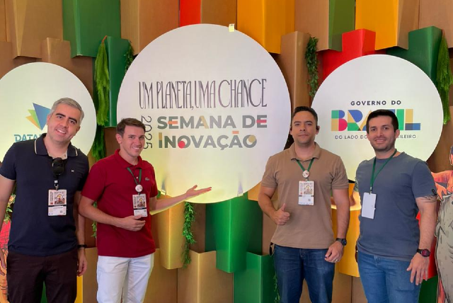 Da esquerda para a direita: Maurício Amaral, Antonio Airton, Lucas Holanda e Juan Arenas (Foto: divulgação) Quatro homens posam para foto. Todos estão com crachá de identificação. Atrás deles, um cenário colorido e um banner com o nome do evento