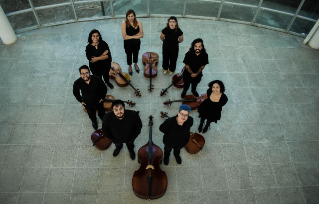 Um concerto gratuito e aberto ao público encerrará a programação às 19h do dia 13 de novembro, na Caixa Cultural Fortaleza (Foto: Divulgação) Fotografia de integrantes do Grupo de Violoncelos da UFC: oito pessoas em círculo, cercando os instrumentos e vistas de cima (Foto: Divulgação)