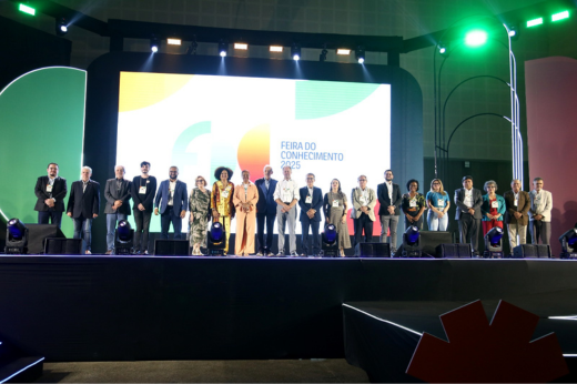 Imagem: Foto das autoridades enfileiradas no palco do evento de abertura da 9ª Feira do Conhecimento