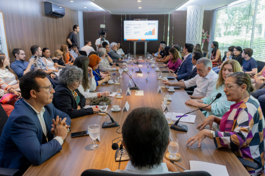 Representantes das instituições que fazem parte do acordo ao redor de uma grande mesa em reunião