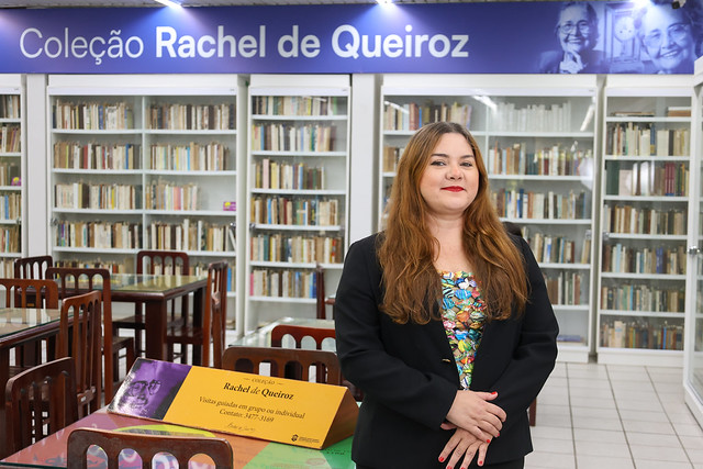 Eleito como melhor trabalho do PPGCI em 2024, o estudo destaca ainda o contexto histórico e cultural no qual se desenvolveu o Modernismo no Brasil (Foto: Viktor Braga / UFC Informa) Imagem: Pesquisadora posa para foto em frente a uma estante de livros