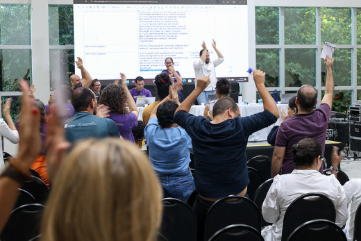 Fotografia de pessoas votando em plenária do Congresso Estatuinte da UFC (Foto: Viktor Braga / Secom-UFC)