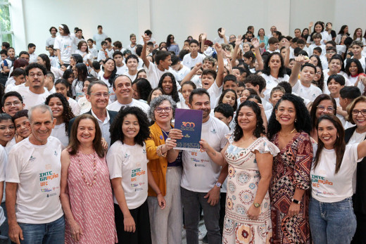 Fotografia da vice-reitora da UFC, professora Diiana Azevedo, e do secretário de Educação de Fortaleza, Idilvan Alencar, segurando o convênio assinado, junto a demais autoridades e estudantes (Foto: Viktor Braga / Secom - UFC)