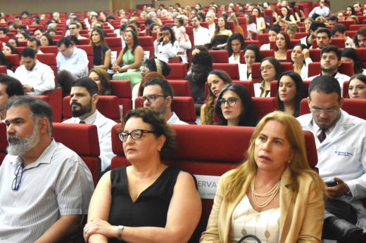 Pessoas que participaram da solenidade sentadas nas cadeiras do auditório