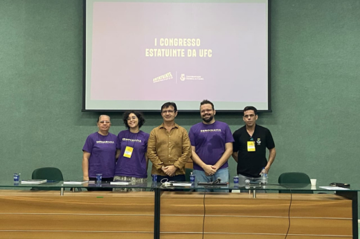 Imagem: Foto posada de membros da Comissão Organizadora da Estatuinte em pé junto com o reitor Custódio Almeida