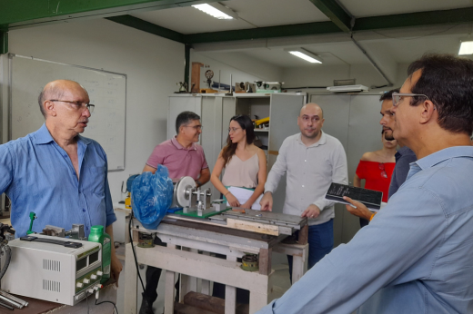 Pessoas no laboratório de vibrações observando o funcionamento