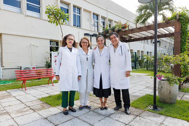 Imagem: Foto da médica cardiologista e professora Isabela Takakura ao lado da equipe de pesquisa no jardim do Hospital Universitário Walter Cantídio 