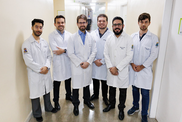 Imagem: Foto da equipe de pesquisadores liderada pelo médico neurologista e professor Paulo Ribeiro Nóbrega enfileirados em um dos corredores do Hospital Universitário Walter Cantídio