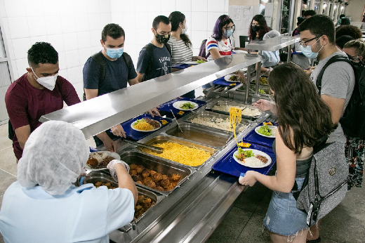 Alunos colocam refeições em seus pratos no RU