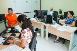 Imagem: foto de pessoas sentadas cada uma em frente a um computador