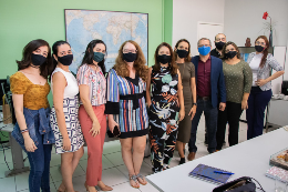 pessoas de máscaras e abraçadas posando para foto