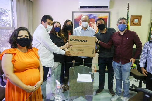 Imagem: Oito pessoas, entre homens e mulheres, segurando uma caixa com um dos equipamentos entregues ao Campus de Crateús (Foto: Divulgação/SECITECE)