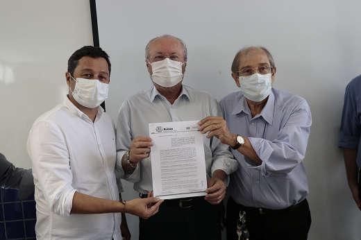 Imagem: Sávio Gurgel (prefeito de Russas), Prof. Cândido Albuquerque (reitor da UFC) e Prof. Lindberg Gonçalves (diretor do Campus da UFC em Russas) seguram protocolo de intenções assinado entre Universidade e prefeitura. (Foto: Viktor Braga)