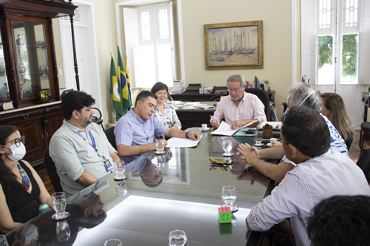 Imagem: Foto mostra reunião com o reitor Cândido Albuquerque (ao centro), ladeado pela comitiva da Prefeitura de Chorozinho e pela equipe da SECULT-UFC. Todos estão sentados à mesa no Gabinete. (Foto: Lamonier Rodrigues/ UFC Informa)