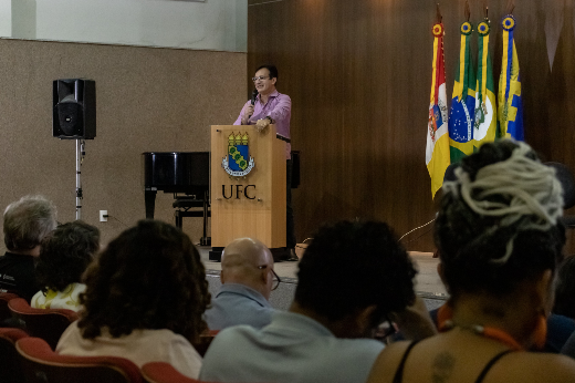 Imagem: reitor Custódio Almeida em pé no palco, atrás do púlpito