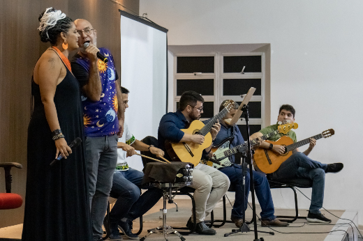 Imagem: servidores no palco cantando e tocando